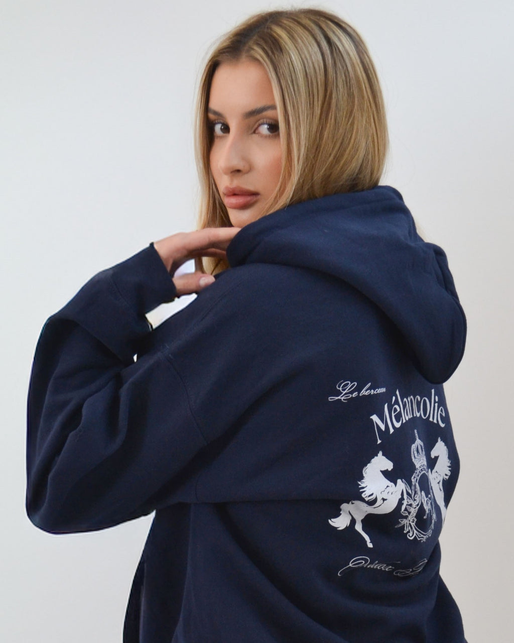 Model wearing the Mélancolie Hoodie in navy by Vandox - an oversized luxury hoodie showcasing the iconic Vandox Melancolie Crest on the back. A statement of quiet power and refined streetwear elegance from the Vandox Famille collection. Starboy old money hoodie sweatshirt clothes vandox sacrevandox vandox clothes vandox clothing