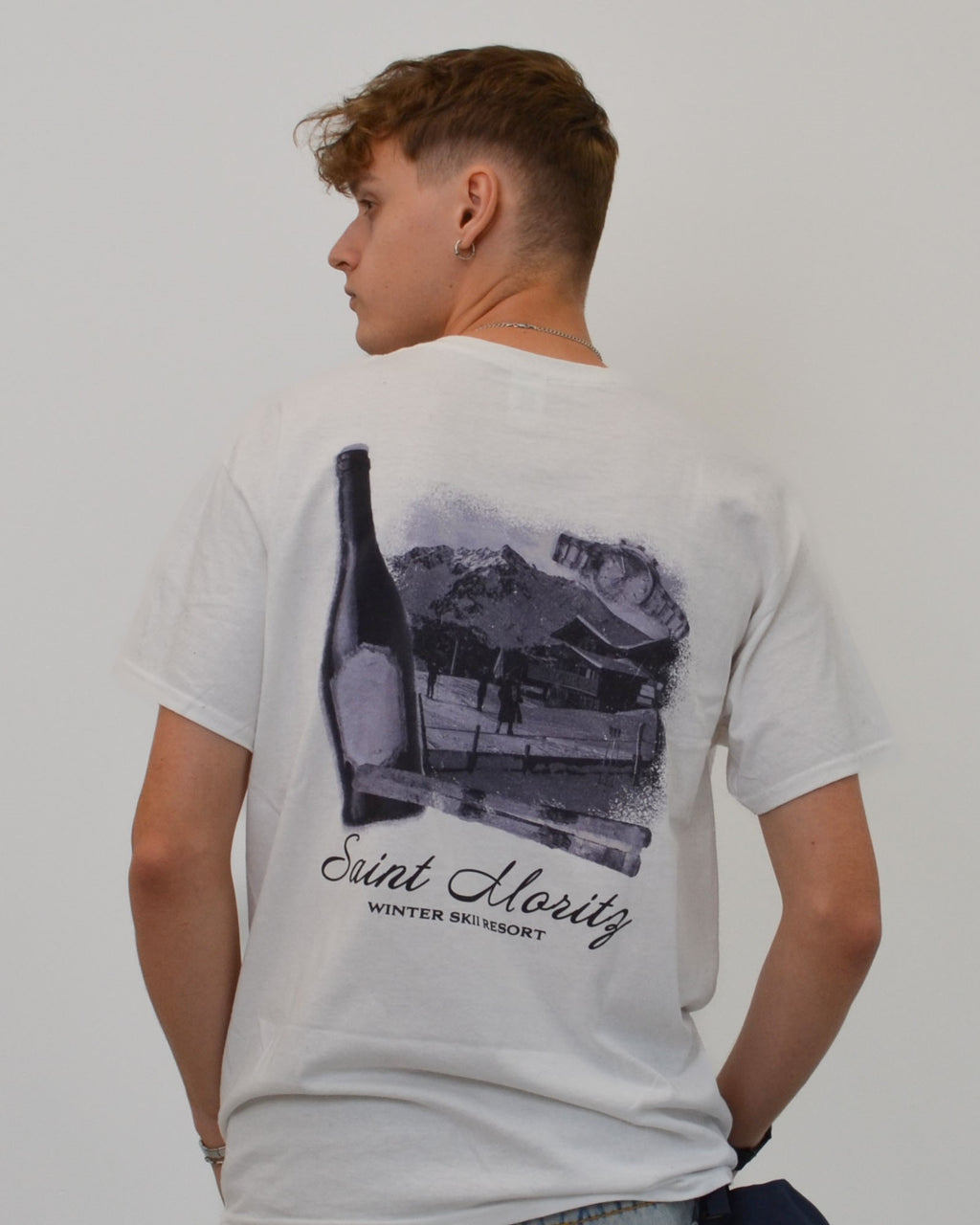 Male model wearing the Alpine Ski Club T-Shirt in white - a premium oversized tee featuring the “Saint Moritz Winter Ski Resort” print. A signature Vandox design inspired by alpine luxury and vintage ski culture, blending timeless resort elegance with contemporary streetwear minimalism. Starboy old money shirt tshirt clothes vandox sacrevandox vandox clothes vandox clothing