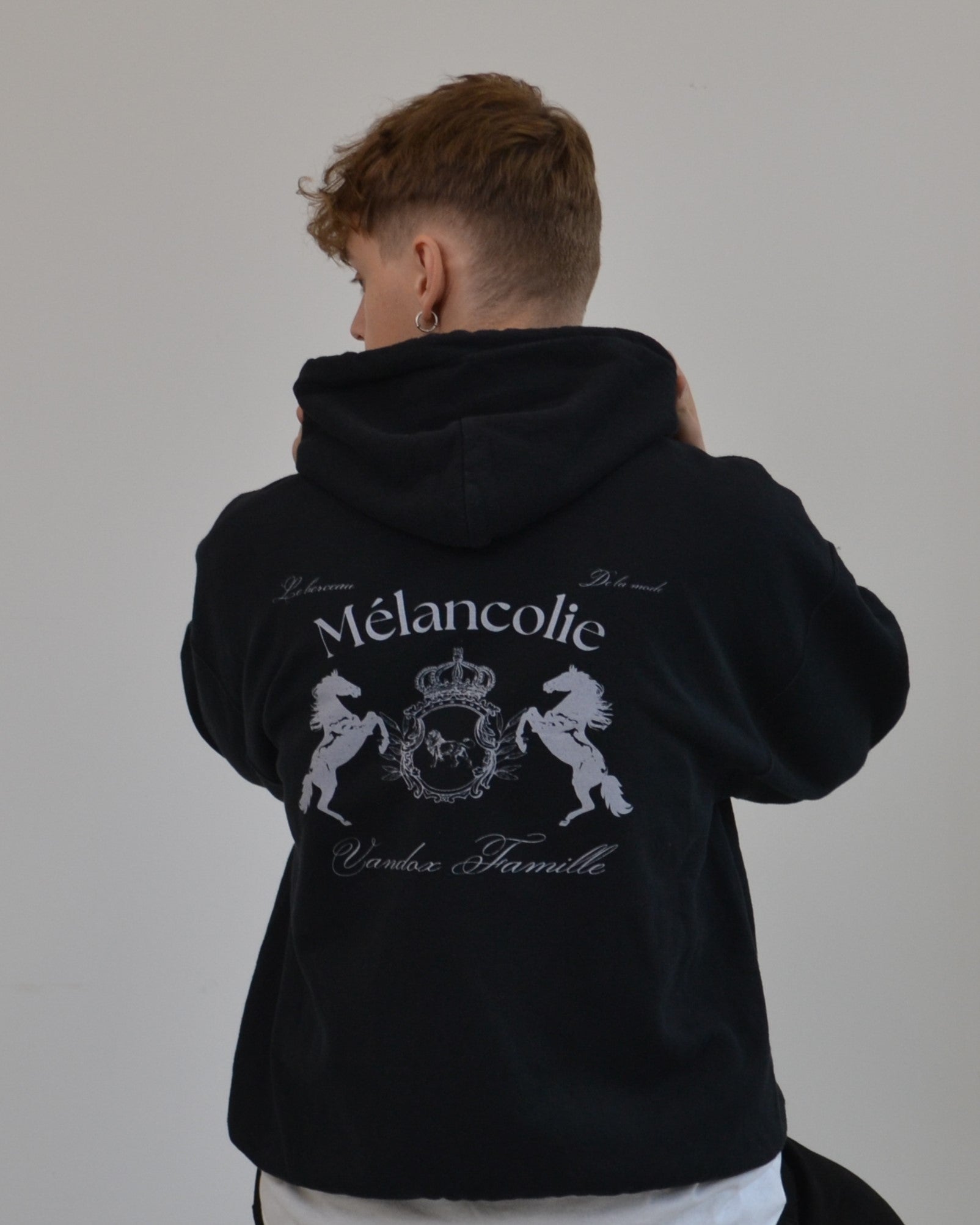 Model wearing the Mélancolie Hoodie in black by Vandox - a premium oversized hoodie featuring the signature Vandox Famille crest. A timeless piece blending aristocratic heritage with modern streetwear sophistication. Starboy old money hoodie sweatshirt clothes vandox sacrevandox vandox clothes vandox clothing