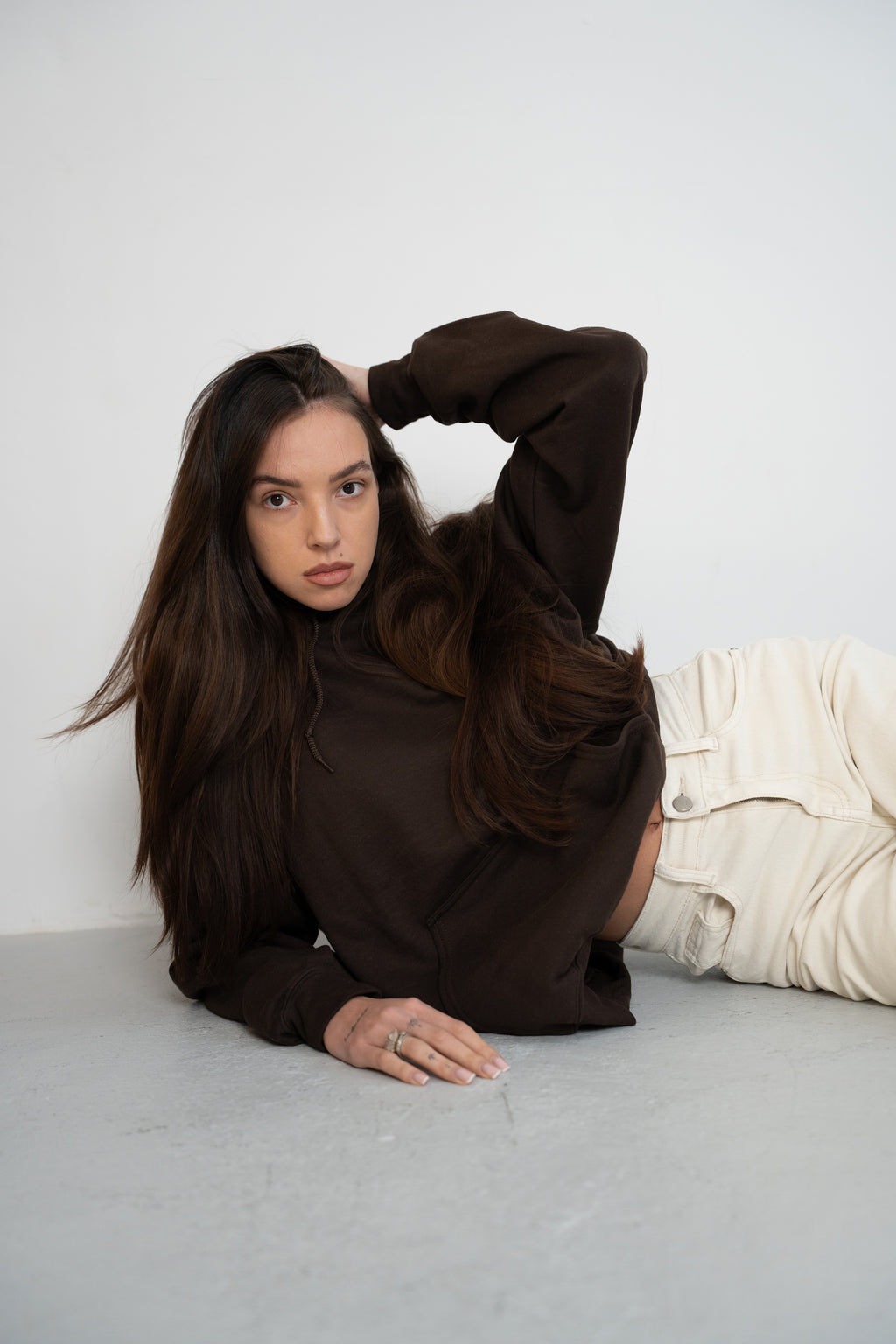 Model wearing Dark Chocolate Brown Vandox Mélancolie Hoodie from Vandox clothing collection, luxury starboy old money aesthetic hoodie styled in minimalist fashion studio setting