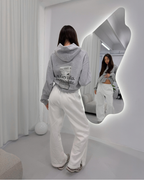 Female Model Wearing Vandox Sport Grey Money Talks Hoodie in front of a mirror