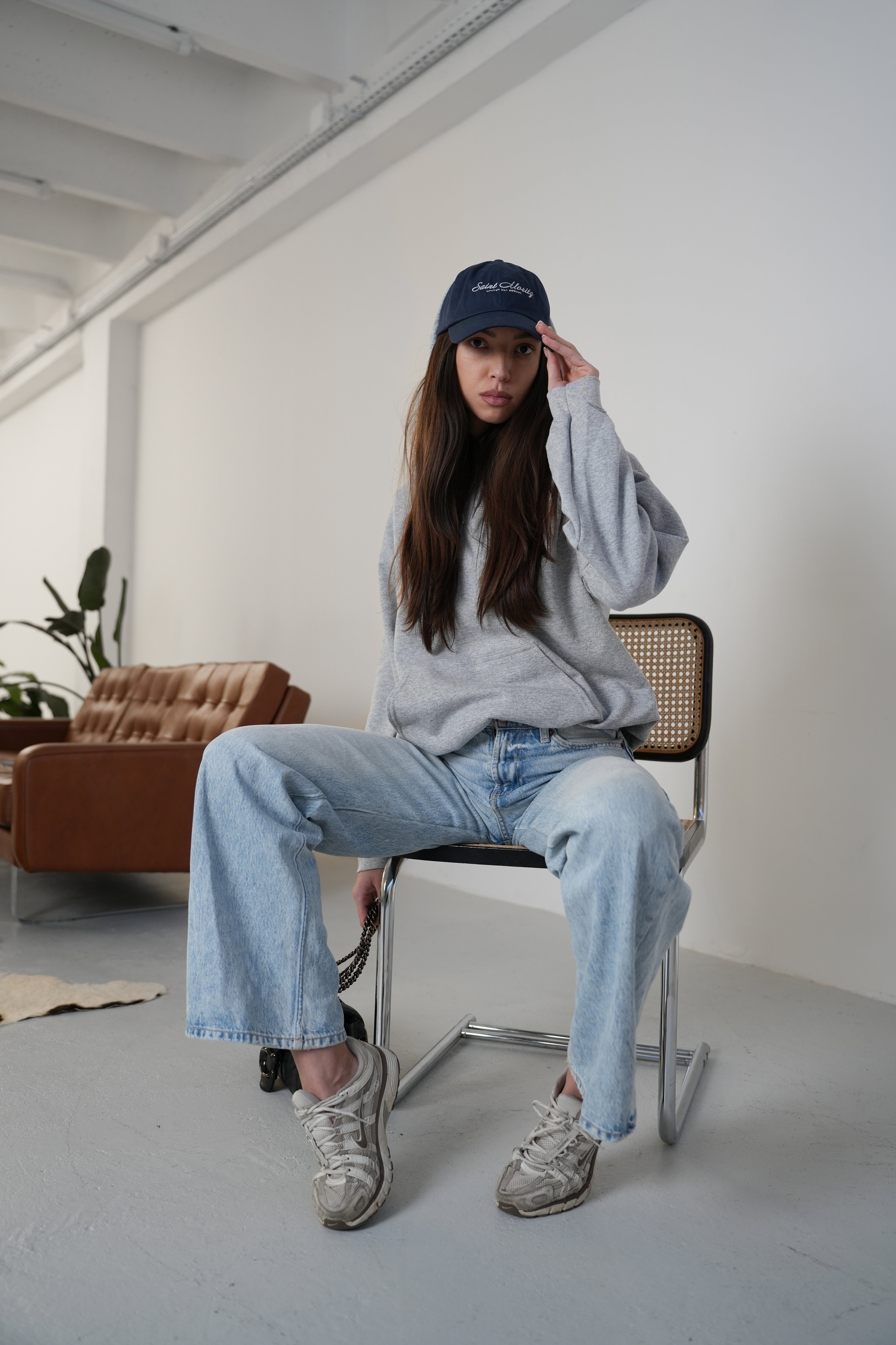 Model wearing Dark Deep Blue Navy Vandox Alpine Escape Cap with embroidered Saint Moritz ski resort design, luxury starboy old money aesthetic baseball cap from Vandox clothing collection