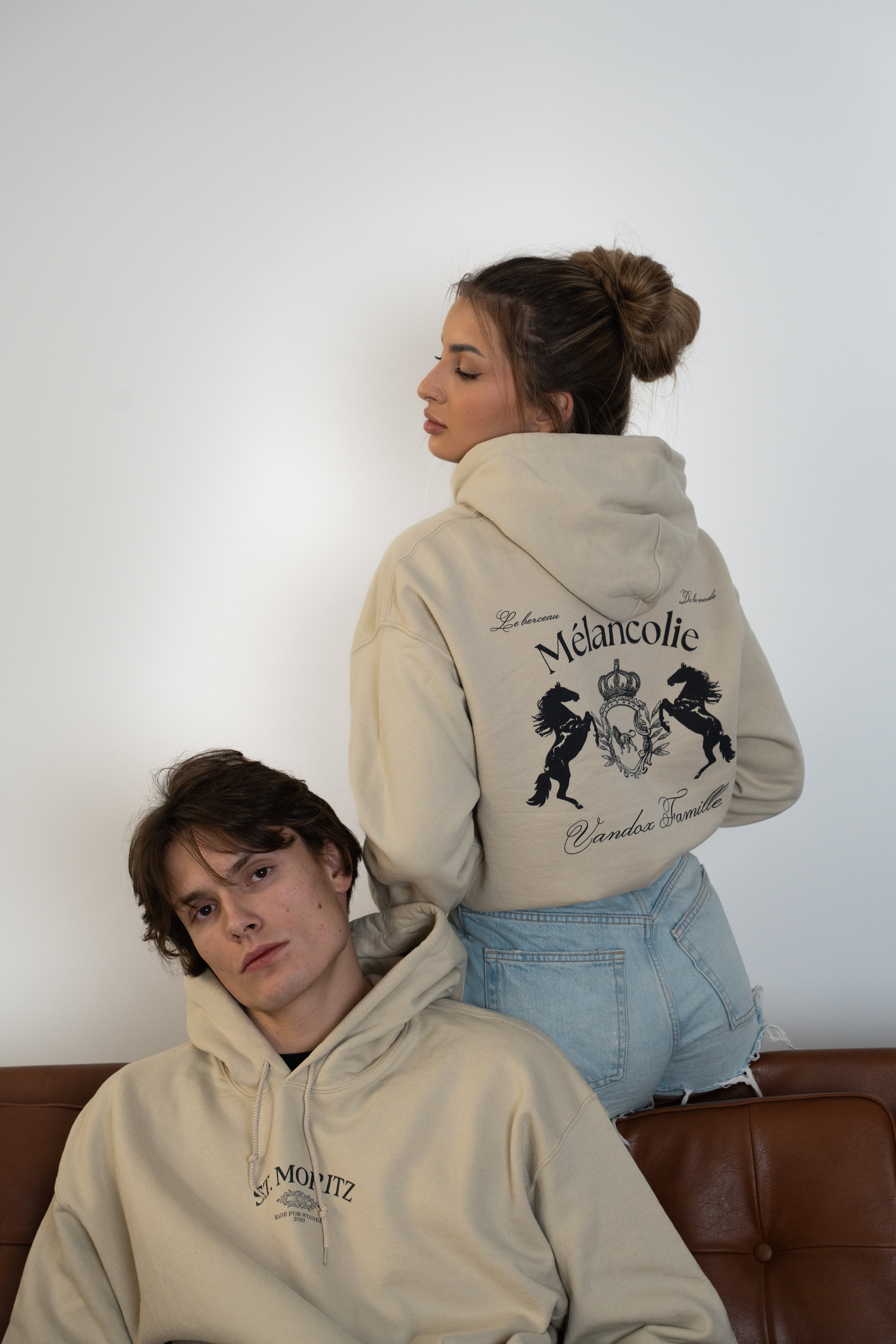 Vandox Mélancolie hoodie in Sand beige worn by two models, featuring vintage crest and horse graphic on the back with a relaxed luxury streetwear aesthetic