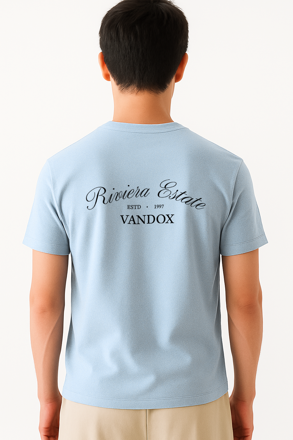 Model wearing the Light Blue Azure Prophecy T-Shirt by Vandox, featuring “Riviera Estate” script and classic branding across the upper back for a refined, heritage-inspired statement.