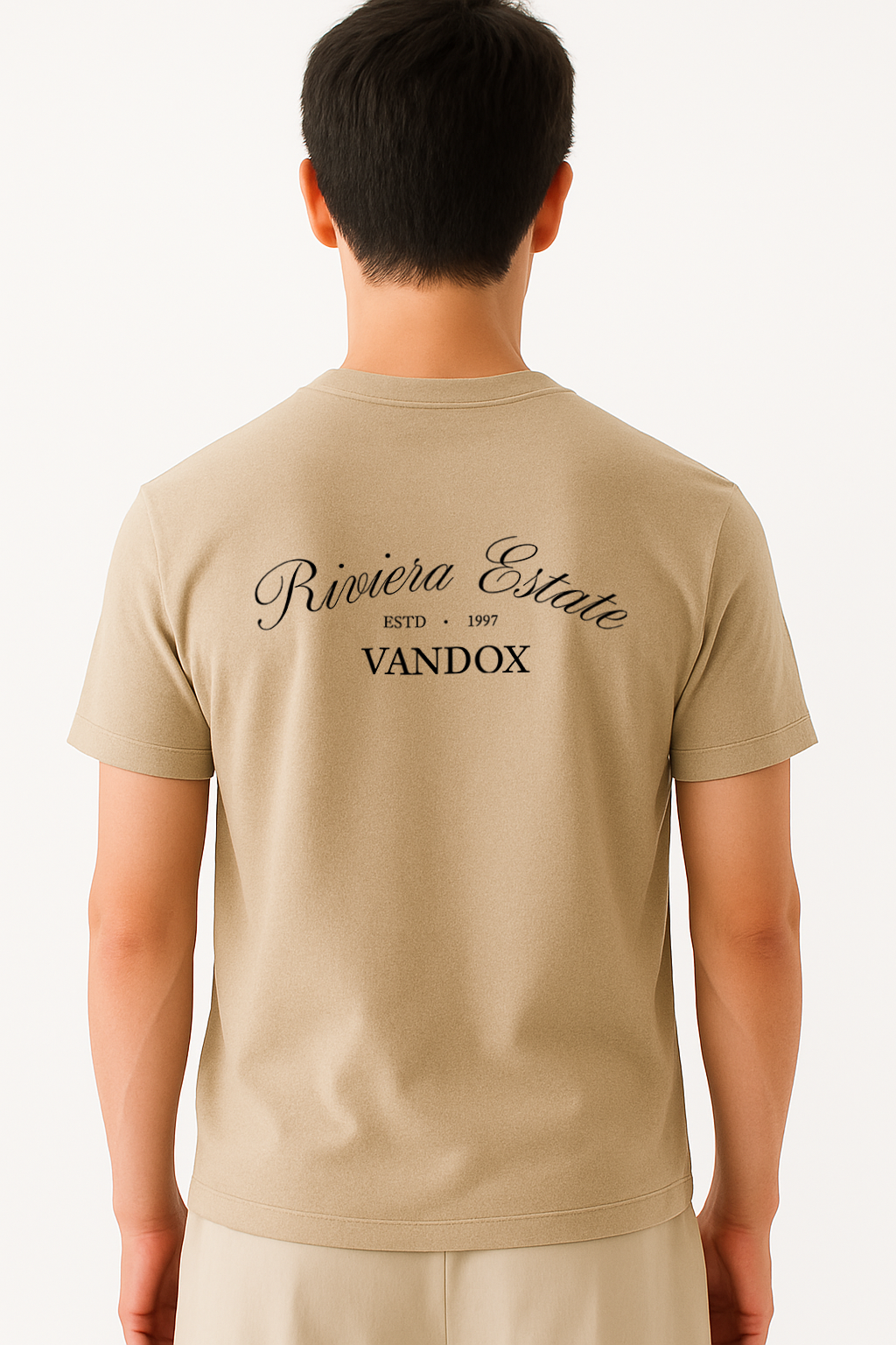 Model wearing the Sand Cream Beige Azure Prophecy T-Shirt by Vandox, featuring “Riviera Estate” script and classic branding across the upper back for a refined, heritage-inspired statement.