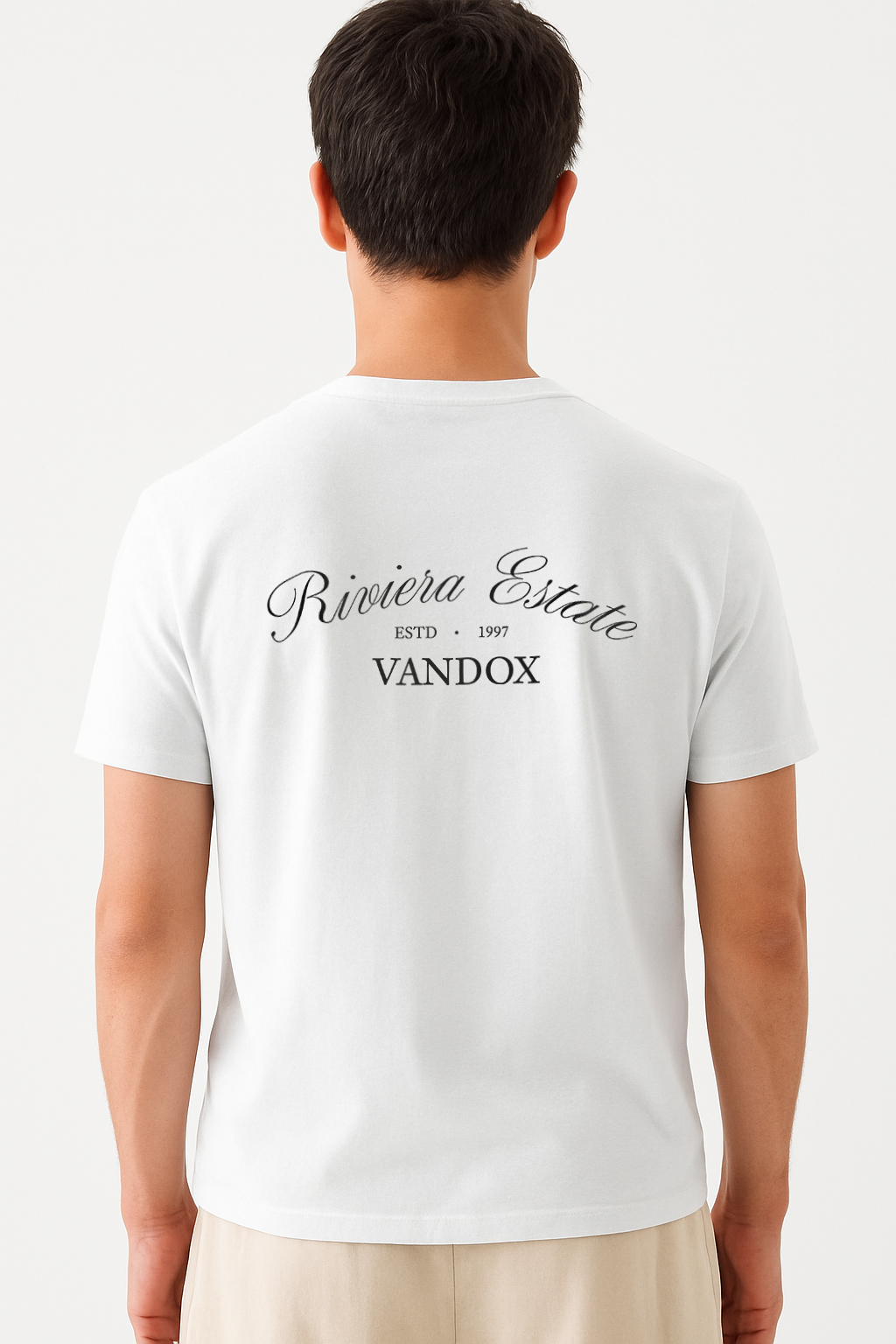 Model wearing the Eggshell White Azure Prophecy T-Shirt by Vandox, featuring “Riviera Estate” script and classic branding across the upper back for a refined, heritage-inspired statement.