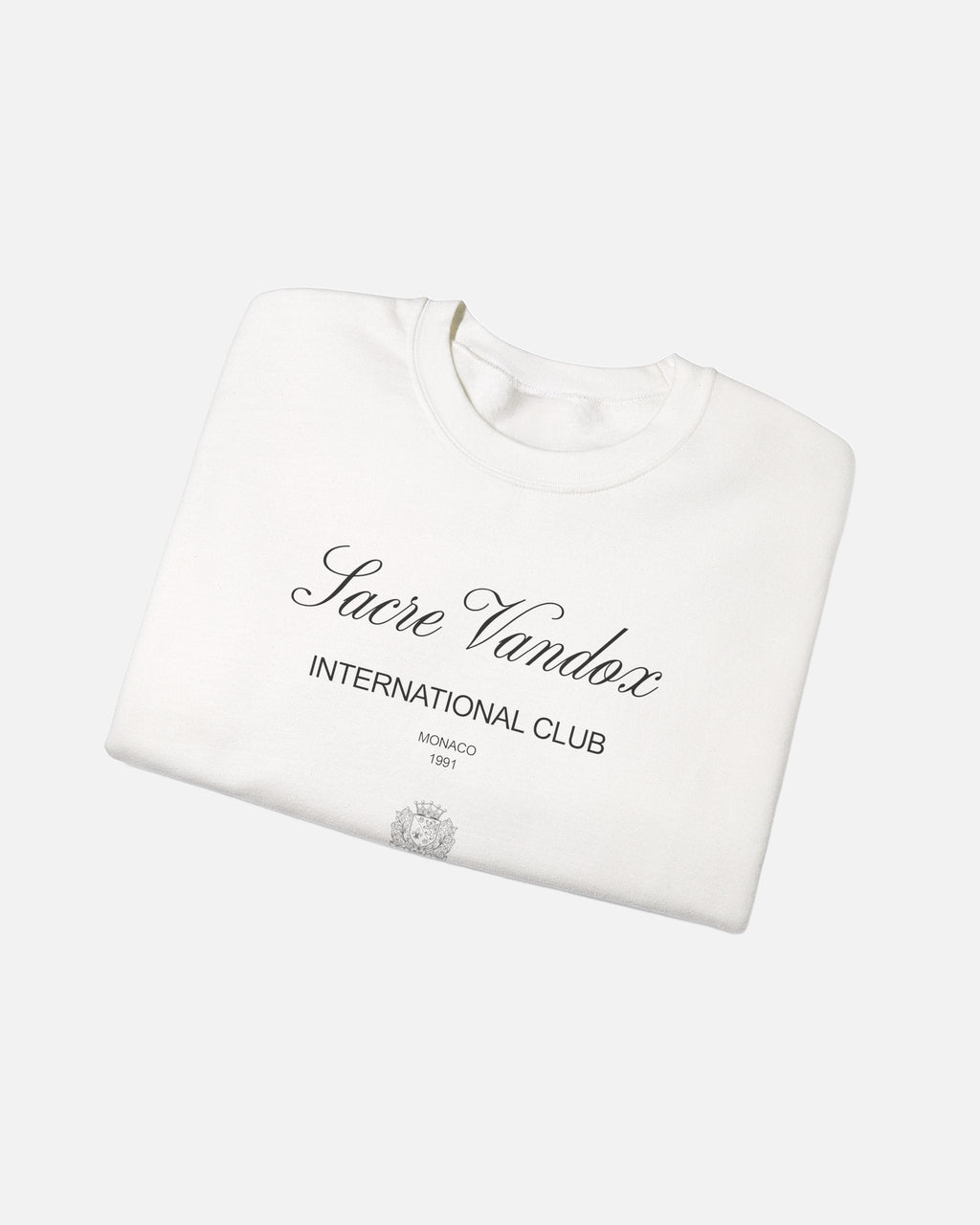 Whtie offwhite eggshell white Vandox Le Rocher Crewneck, folded front view with Sacre Vandox script, International Club Monaco 1991 text and small crest, luxury streetwear crewneck. Starboy old money crewneck sweatshirt clothes vandox sacrevandox vandox clothes vandox clothing