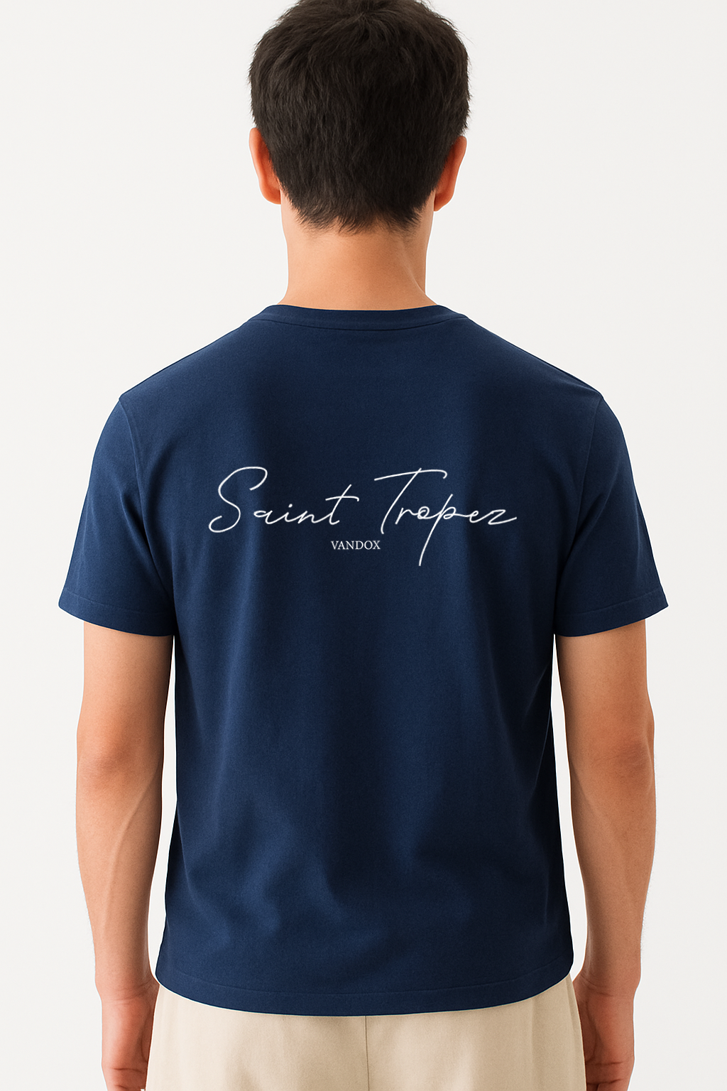 Model wearing the Deep Blue Navy Saint Tropez T-Shirt by Vandox, featuring elegant script typography across the back for a refined, coastal-inspired statement look.