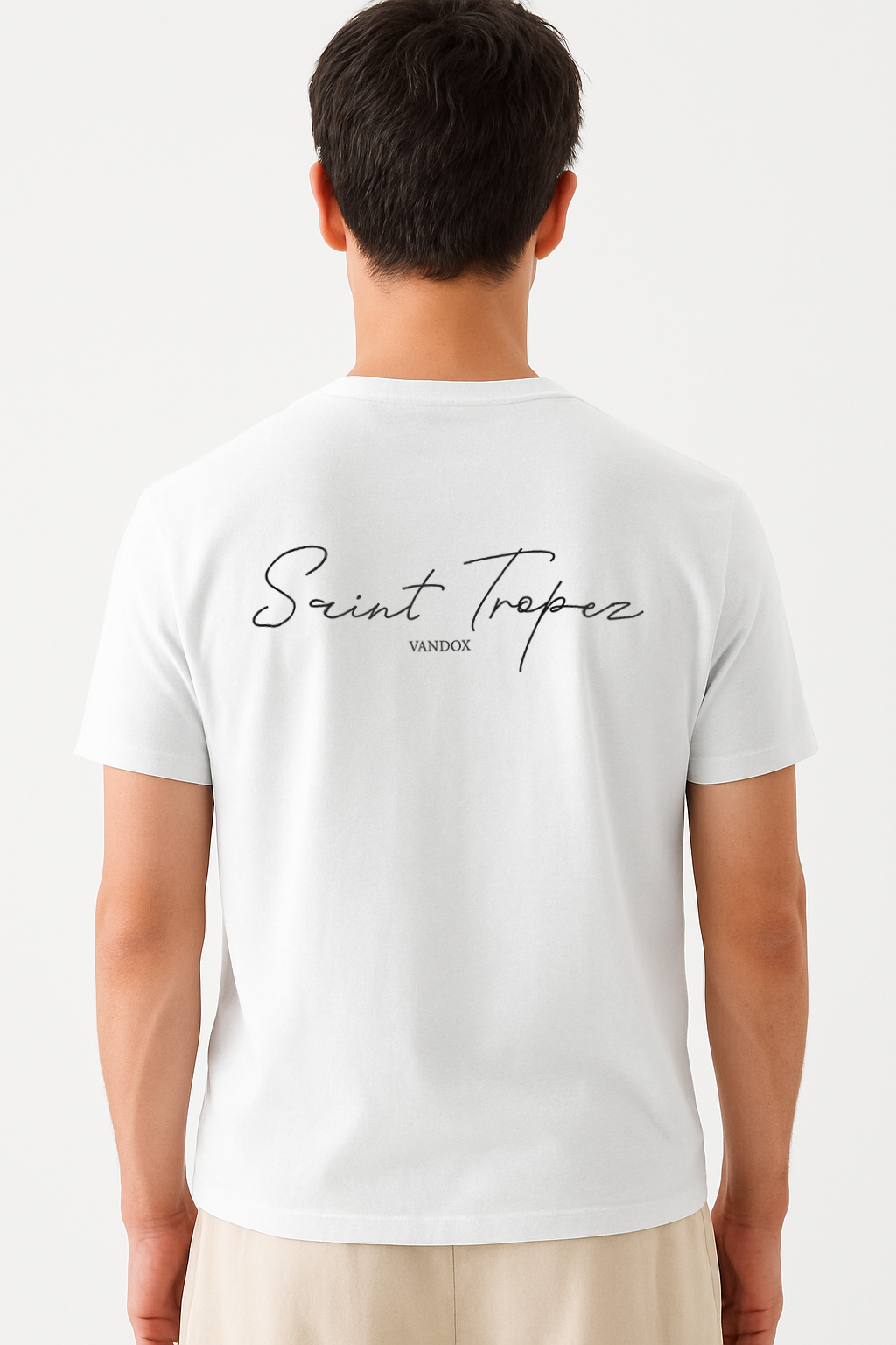 Model wearing the Eggshell White Navy Saint Tropez T-Shirt by Vandox, featuring elegant script typography across the back for a refined, coastal-inspired statement look.