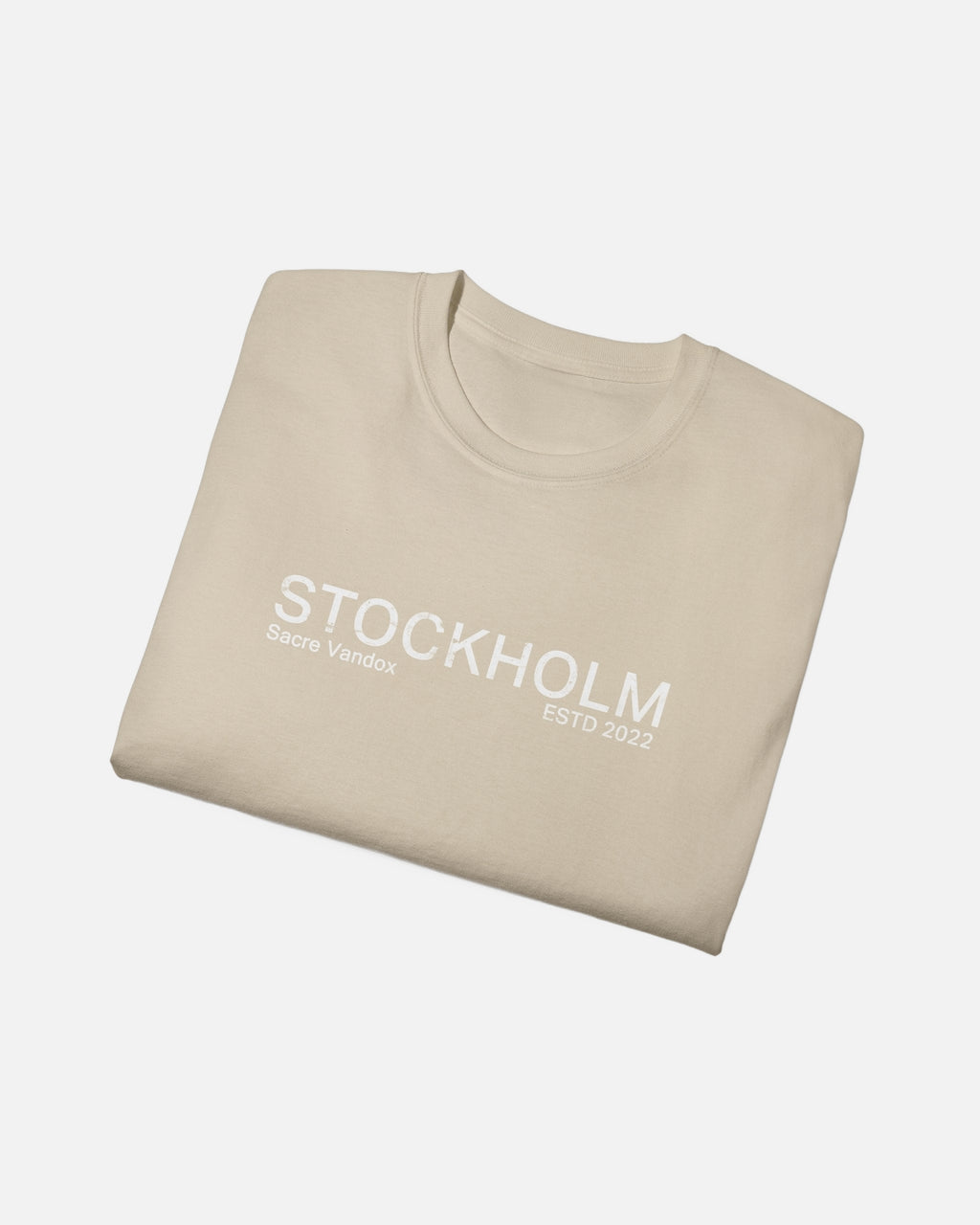 Folded view of Sand Vandox Stockholm t-shirt with distressed STOCKHOLM Sacre Vandox ESTD 2022 front graphic print. Starboy old money shirt tshirt clothes vandox sacrevandox vandox clothes vandox clothing