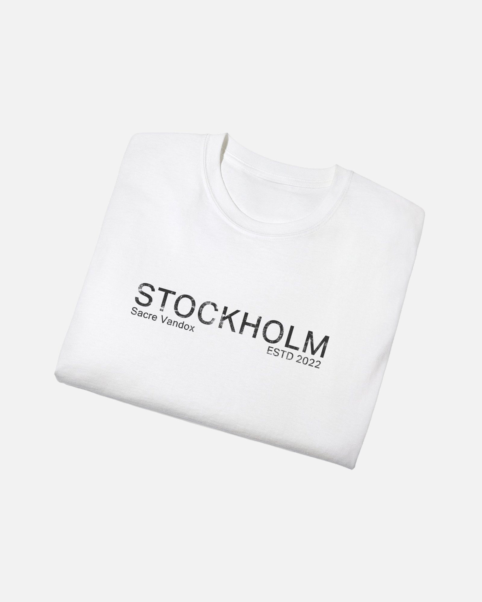 Folded view of White Vandox Stockholm t-shirt with distressed STOCKHOLM Sacre Vandox ESTD 2022 front graphic print. Starboy old money shirt tshirt clothes vandox sacrevandox vandox clothes vandox clothing