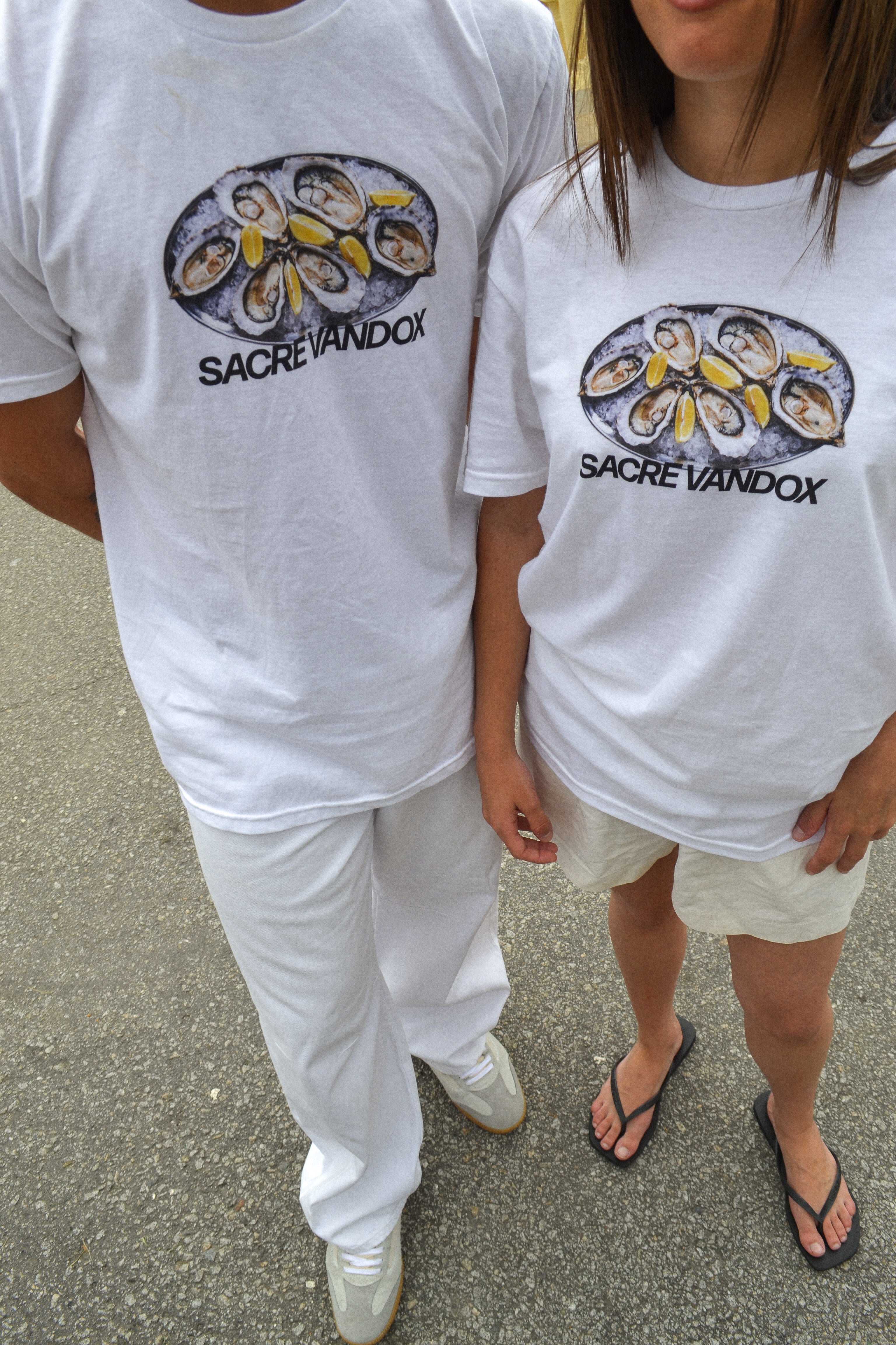 White Vandox Oyster Bar T-shirt worn by a male and female models. Top view perspective.